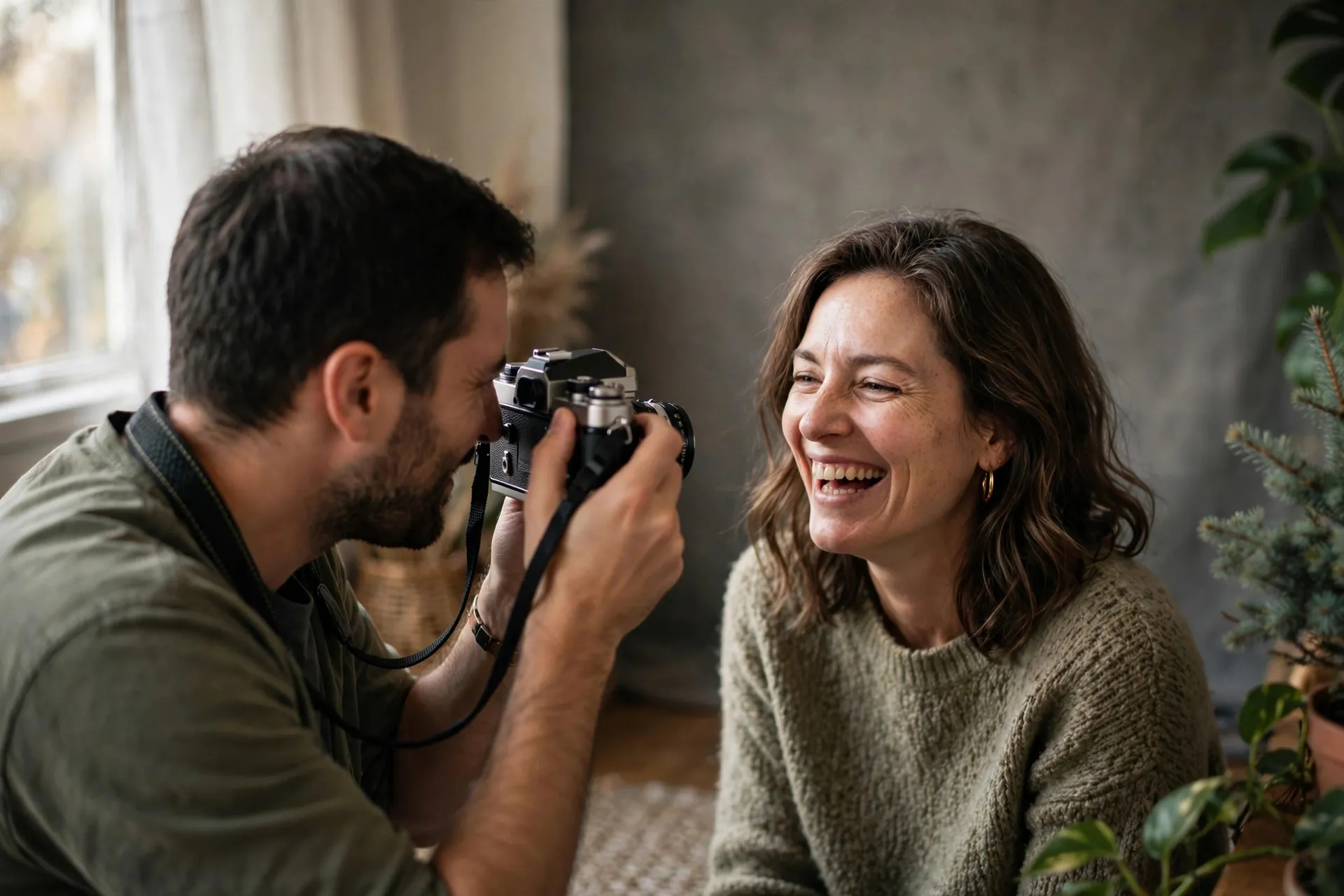 Portrait session: photographer with a film camera and a laughing sitter